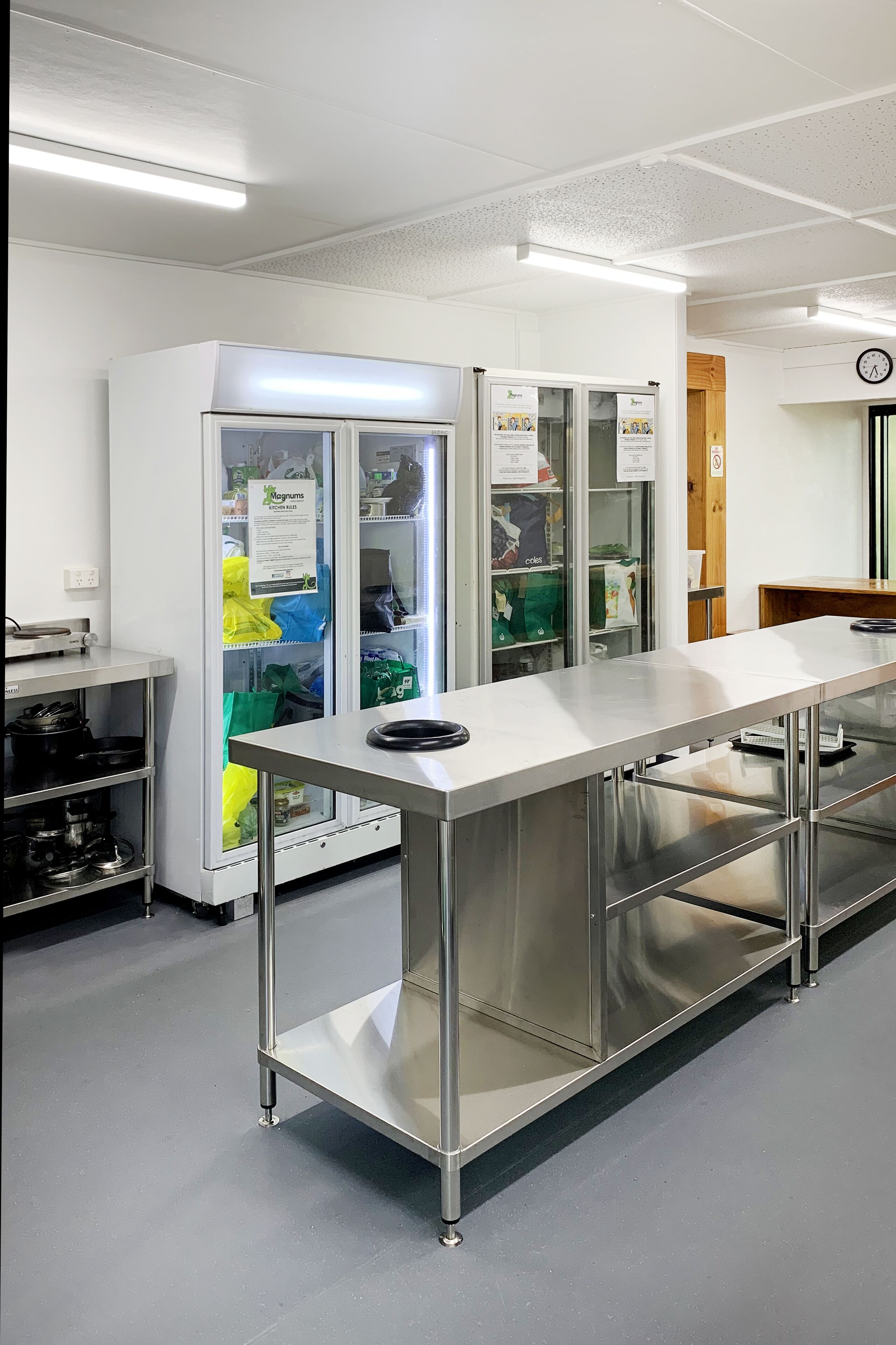 A clean, modern kitchen with stainless steel appliances, a long counter, and storage cabinets.