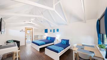A modern room with two beds, a desk, and a chair.