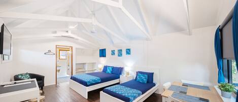 A modern room with two beds, a desk, and a chair.