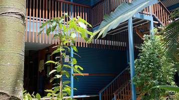 A multi-story building with a blue exterior and a wooden staircase.