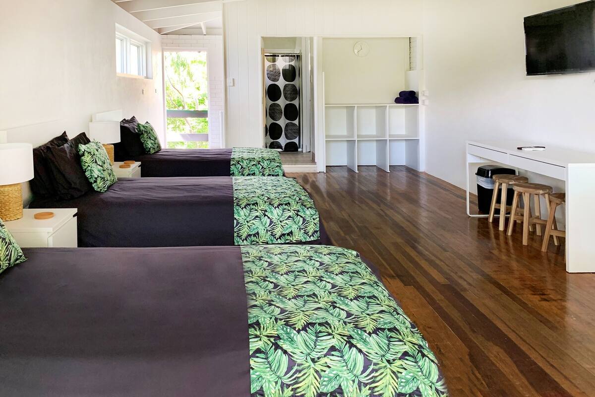 Een moderne hotelkamer met een groot bed, een bureau en een televisie.