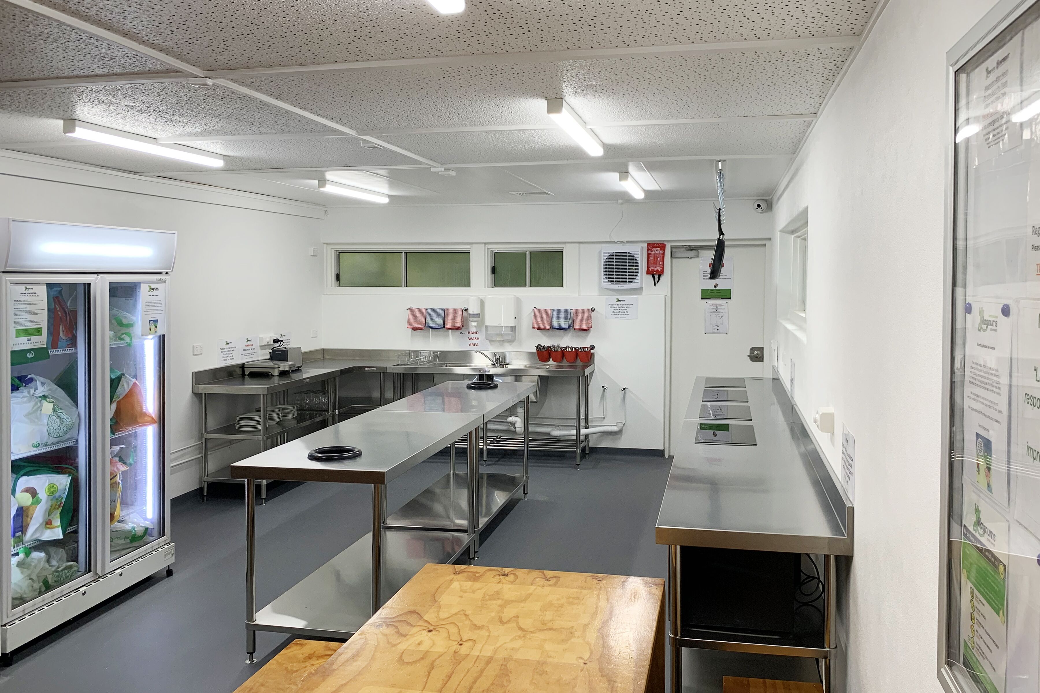 A modern kitchen with stainless steel appliances, a long counter, and a refrigerator.