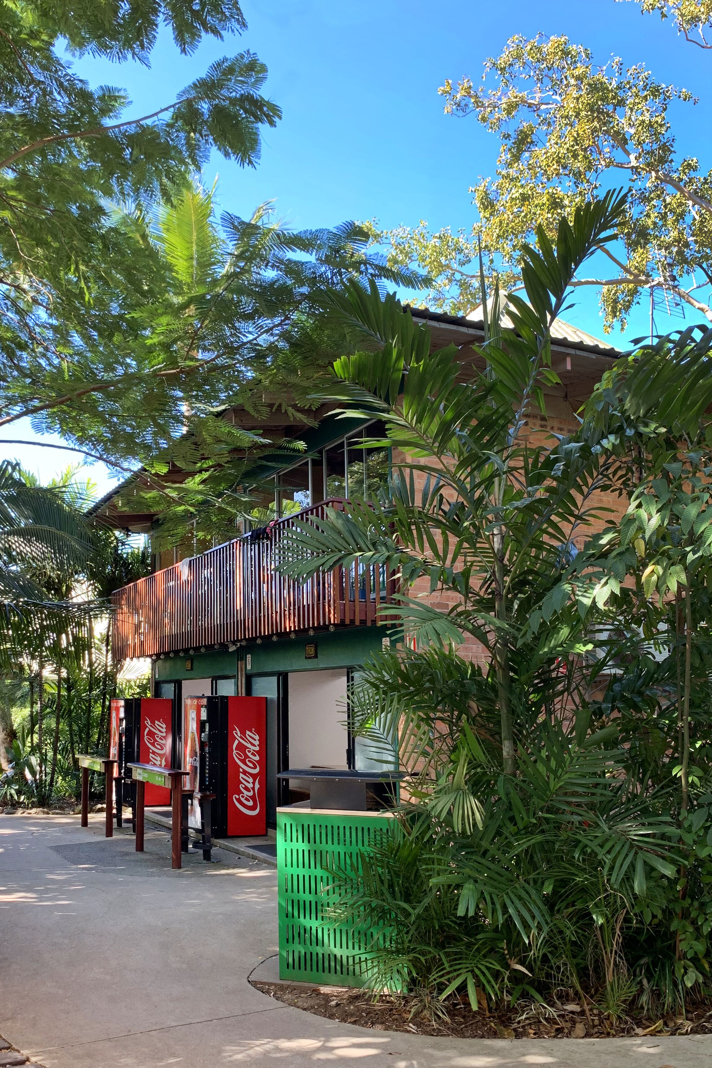 A building with a balcony, surrounded by lush greenery.
