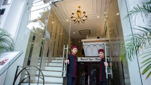 Entrada de un hotel con un letrero que dice 'Marvel Spa - Massage'.
