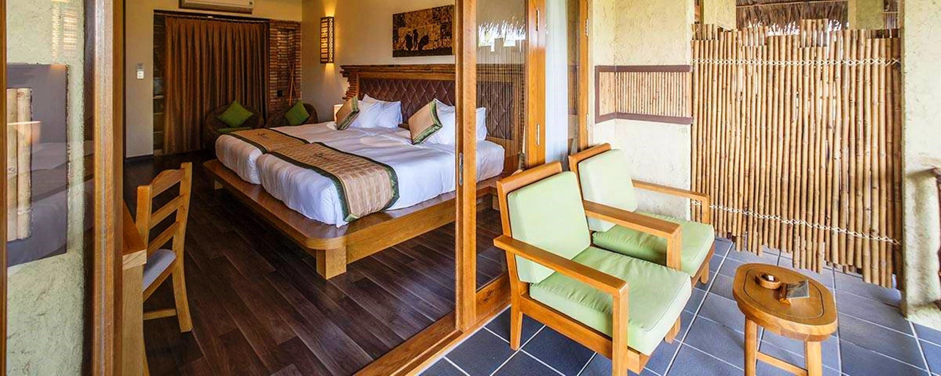 A bedroom with a large bed, two bedside tables, a chair, and a small table.