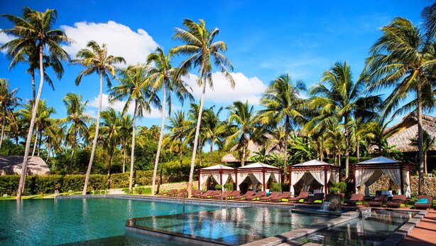 A swimming pool with lounge chairs and palm trees. - Aroma Beach Resort & Spa (Phu Thuy)