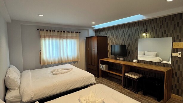 A hotel room with two beds, a TV, a desk, and a large window with curtains. - Dozy Lamoon House (Chiang Mai)