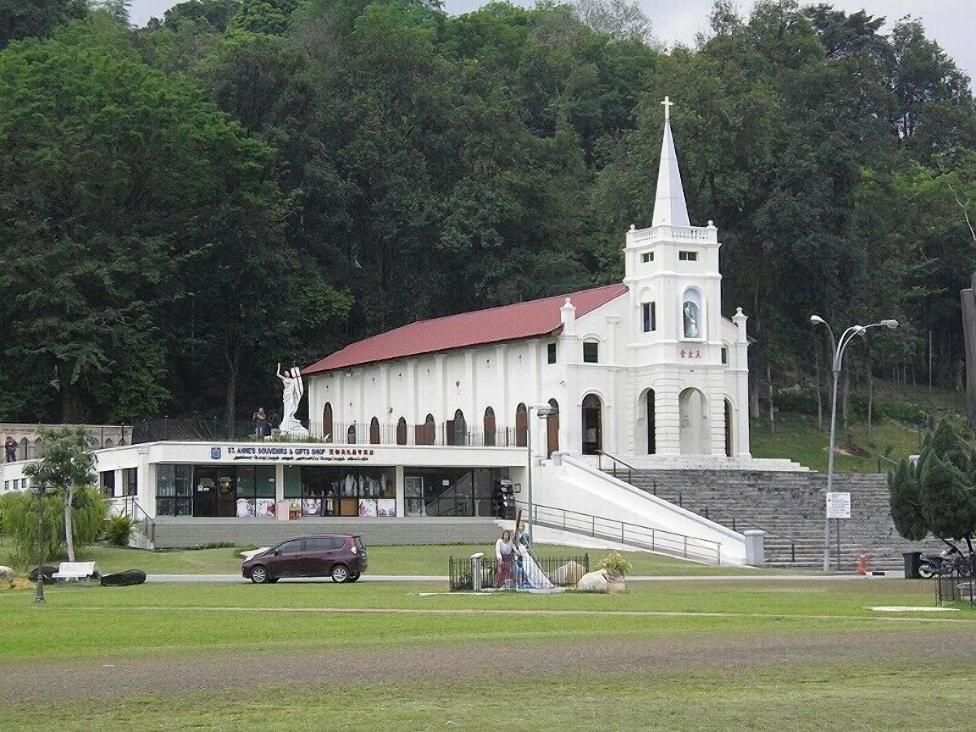 A church with a white facade, a red roof, and a bell tower.