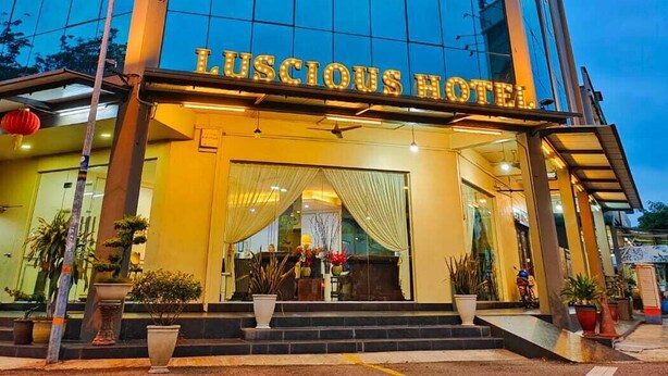 Un edificio moderno de hotel con un letrero llamativo que dice "Lusious Hotel".