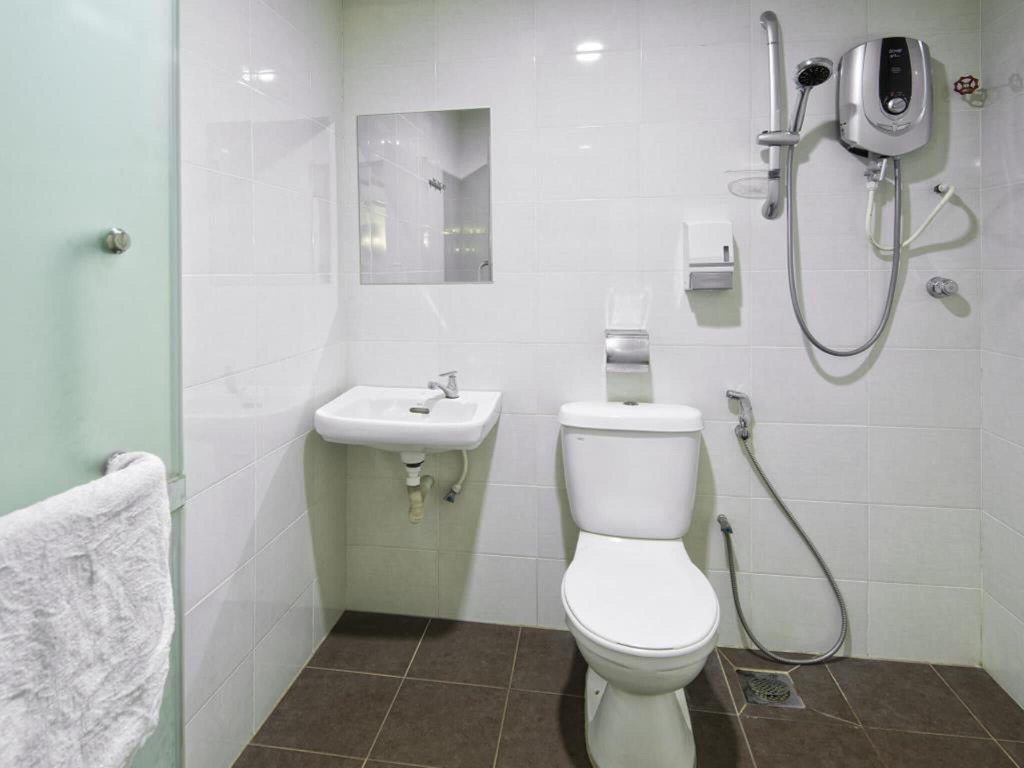 Une salle de bain avec des toilettes, un lavabo et une douche.