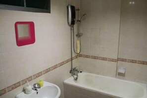 A bathroom with a bathtub, a sink, and a shower. - Putra Place Home Inn (George Town)