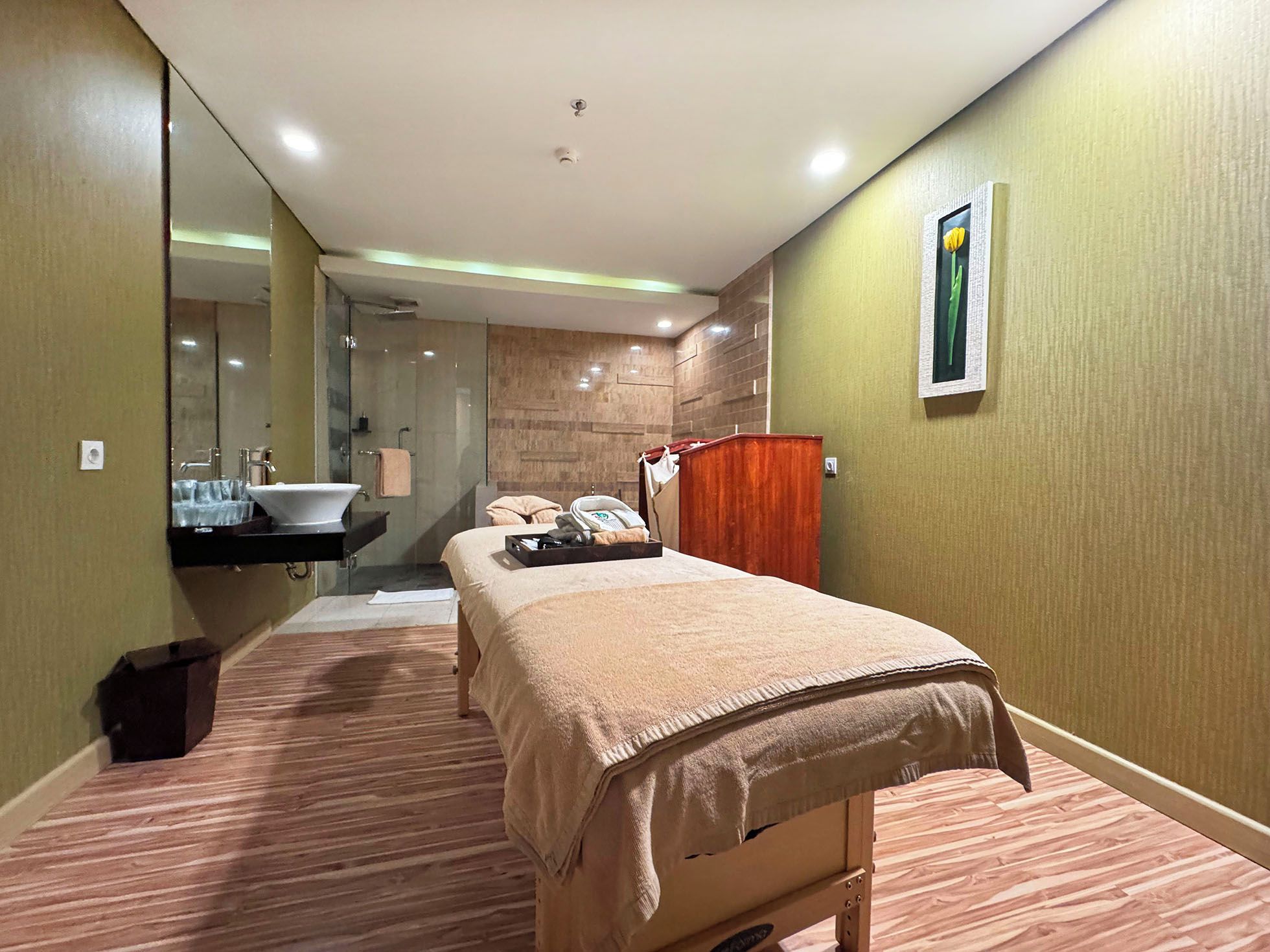 Une chambre d’hôtel avec un lit, une salle de bain avec un lavabo et une armoire en bois.