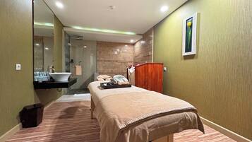 Une chambre d’hôtel avec un lit, une salle de bain avec un lavabo et une armoire en bois.