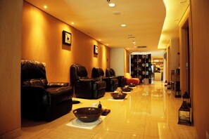 A hotel lobby with leather sofas, a reception desk, and a corridor leading to other areas. - Galaxy Hotel Banjarmasin (Banjarmasin)