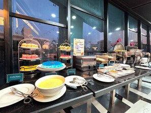 A buffet setup with various food items and utensils. - Galaxy Hotel Banjarmasin (Banjarmasin)