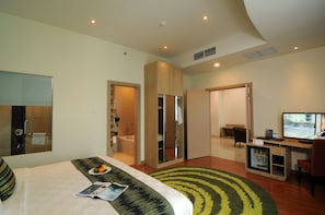 A modern hotel room with a bed, a desk with a computer, a bathroom with a bathtub, and a TV. - Galaxy Hotel Banjarmasin (Banjarmasin)