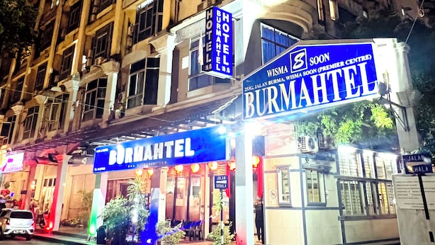Un bâtiment sur lequel on peut voir une enseigne bien visible indiquant « Burma Hotel » et « Wisma Aisama ».