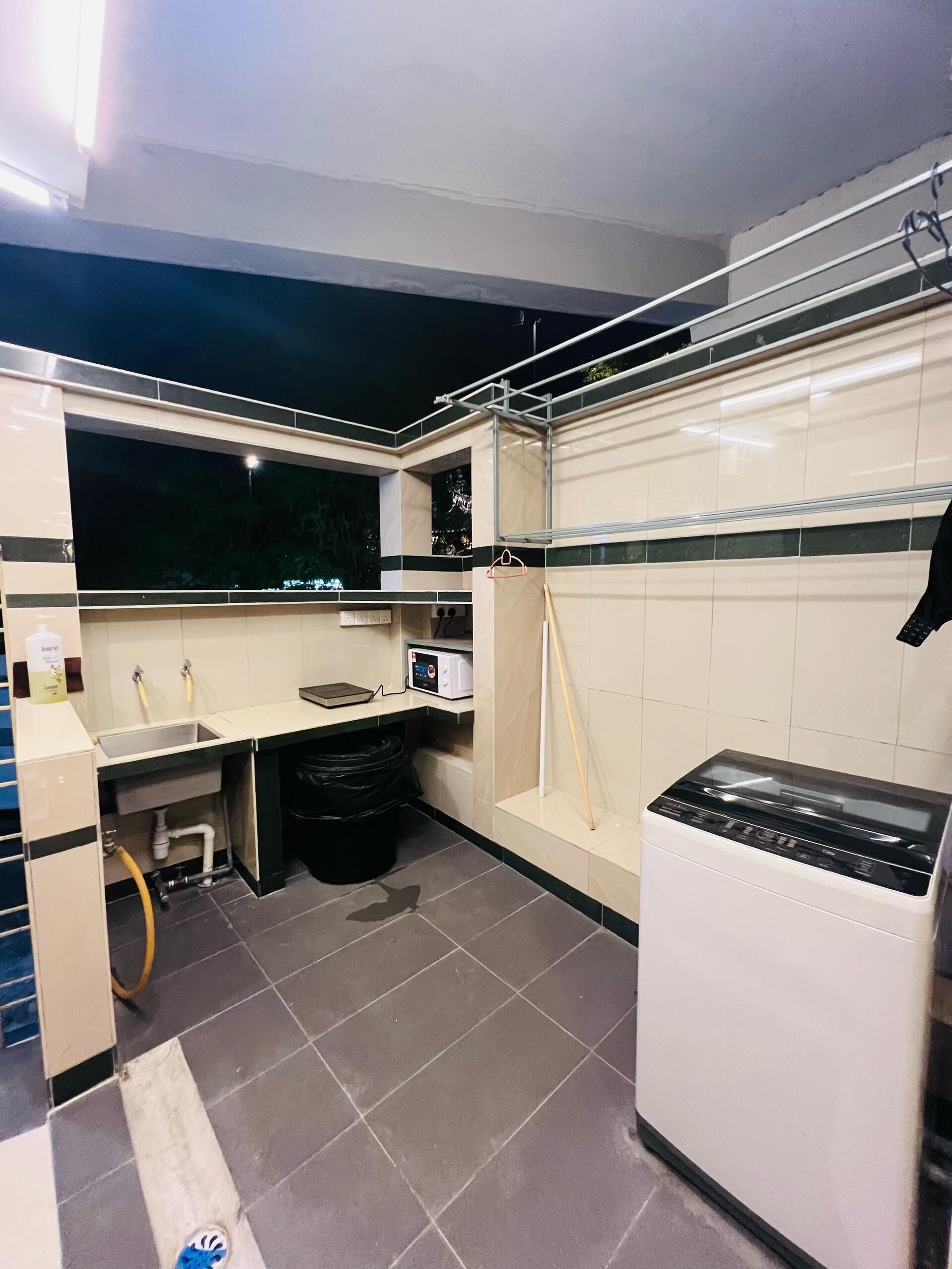 A compact kitchen with a sink, microwave, and a washing machine.