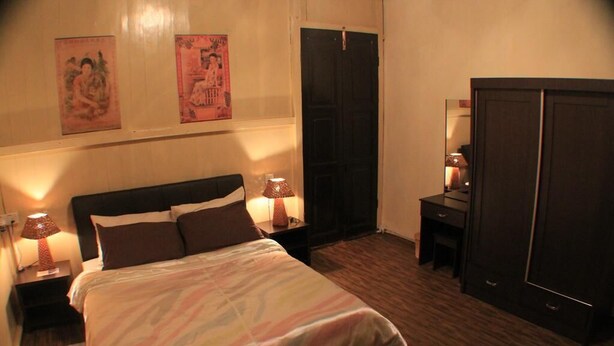 Un dormitorio con cama, mesitas de noche, escritorio y armario.
