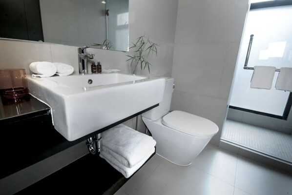 A modern bathroom with a white sink, toilet, and a mirror above the sink. - iSanook Bangkok (Bangkok)