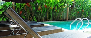 A poolside area with lounge chairs and a pool.