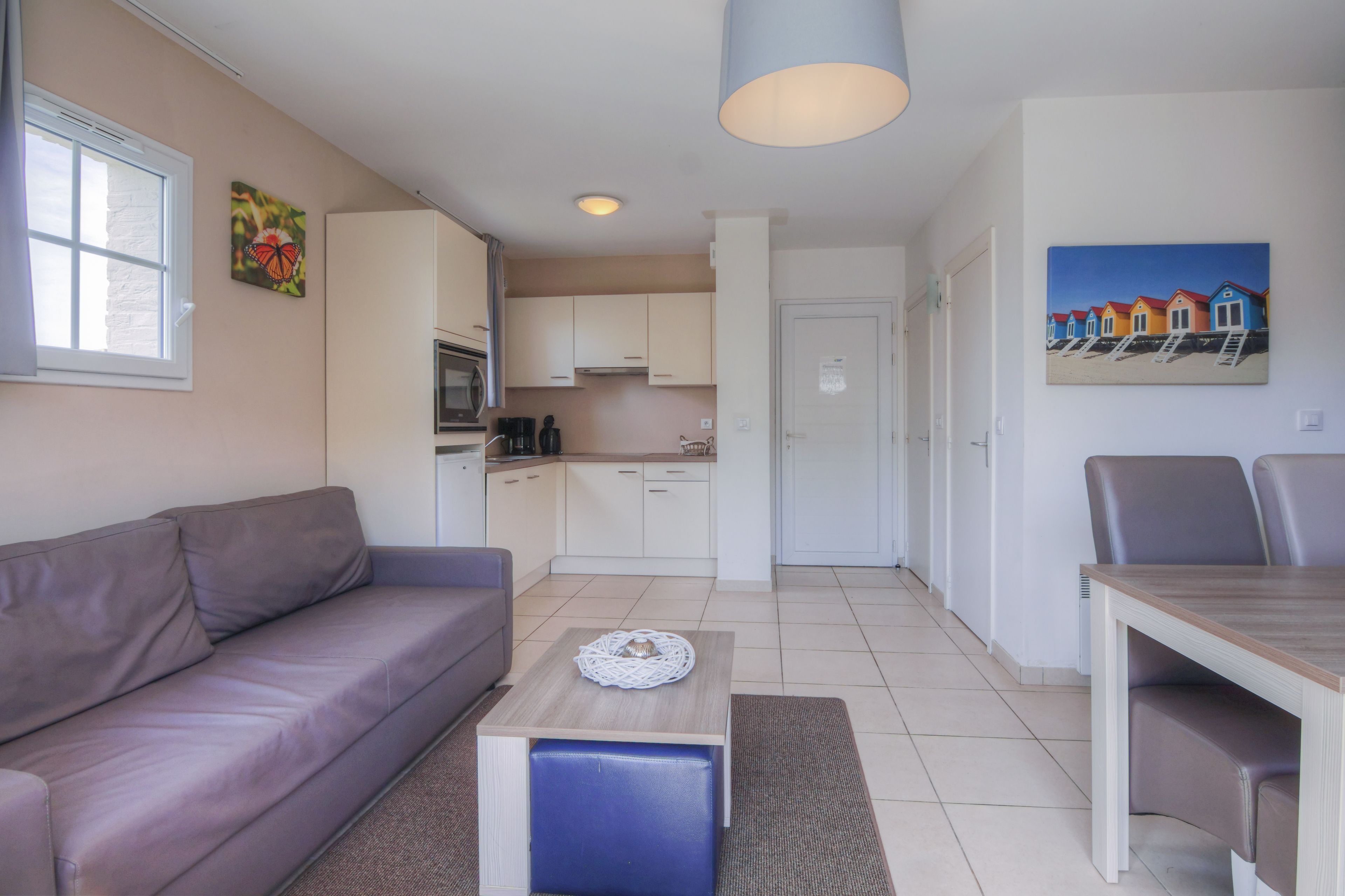 Een moderne woonkamer met een bank, een salontafel en een eethoek met stoelen.