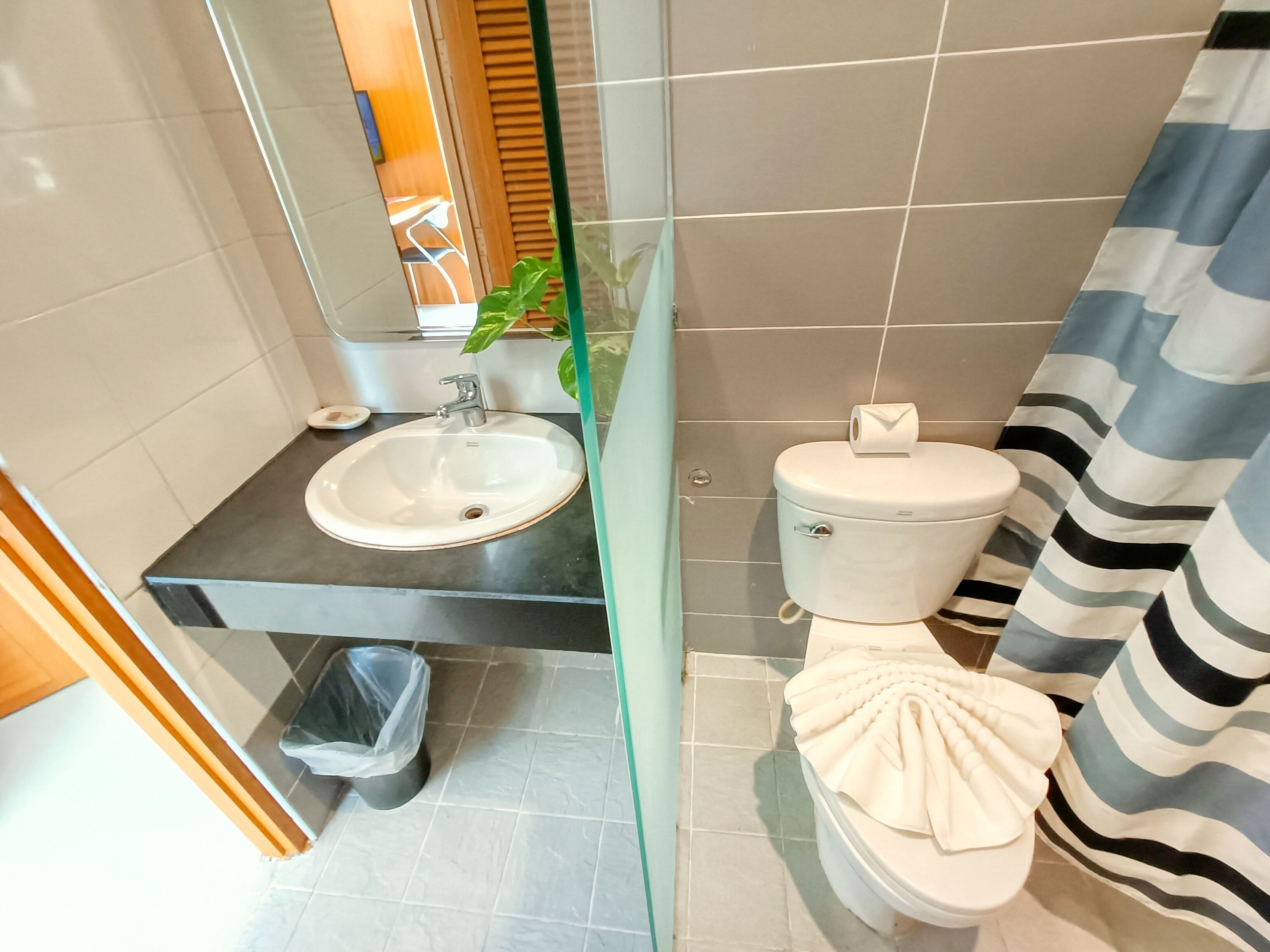 Un baño con lavamanos, inodoro y cortina de ducha.