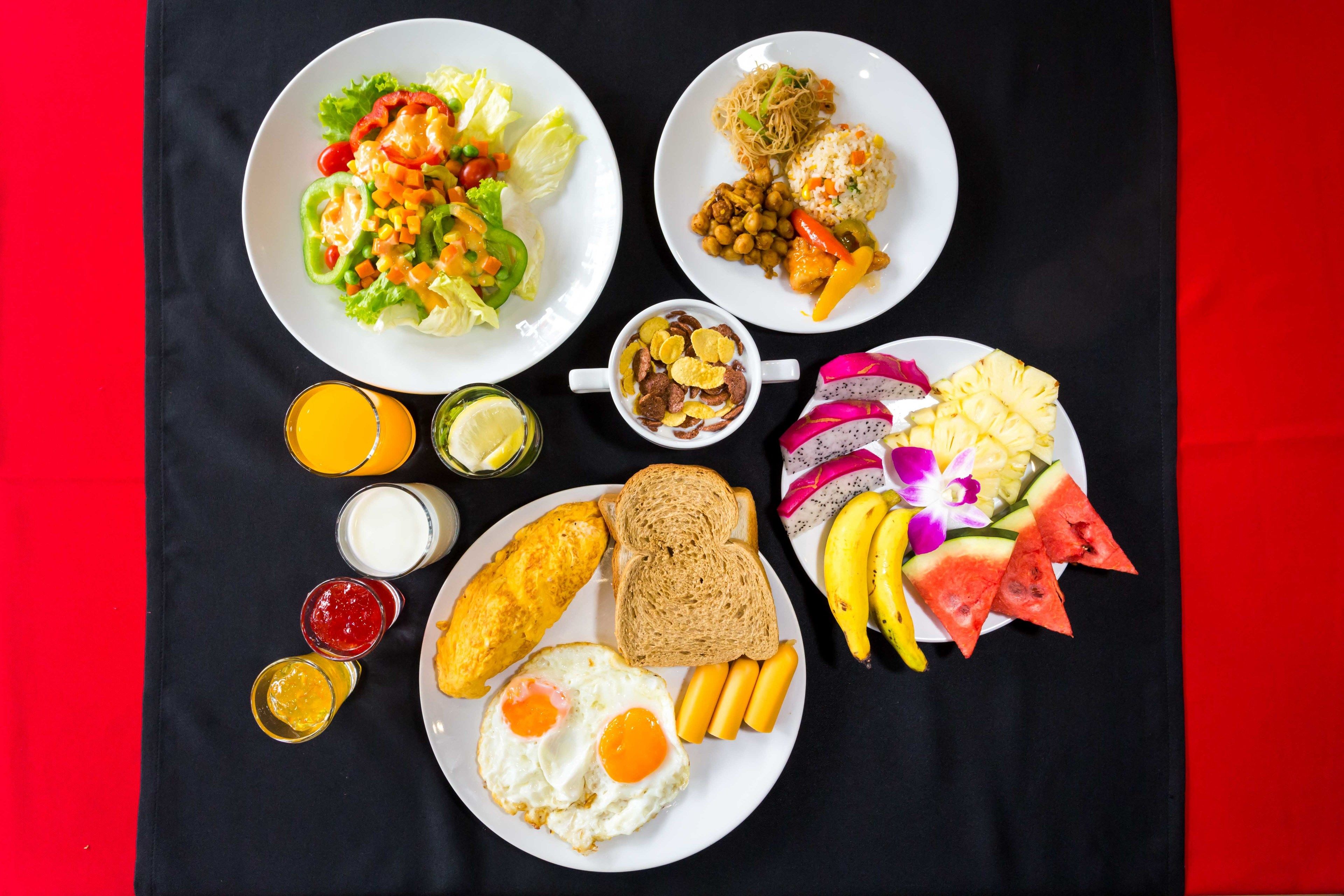 A table with various breakfast items including eggs, toast, fruit, and a salad.
