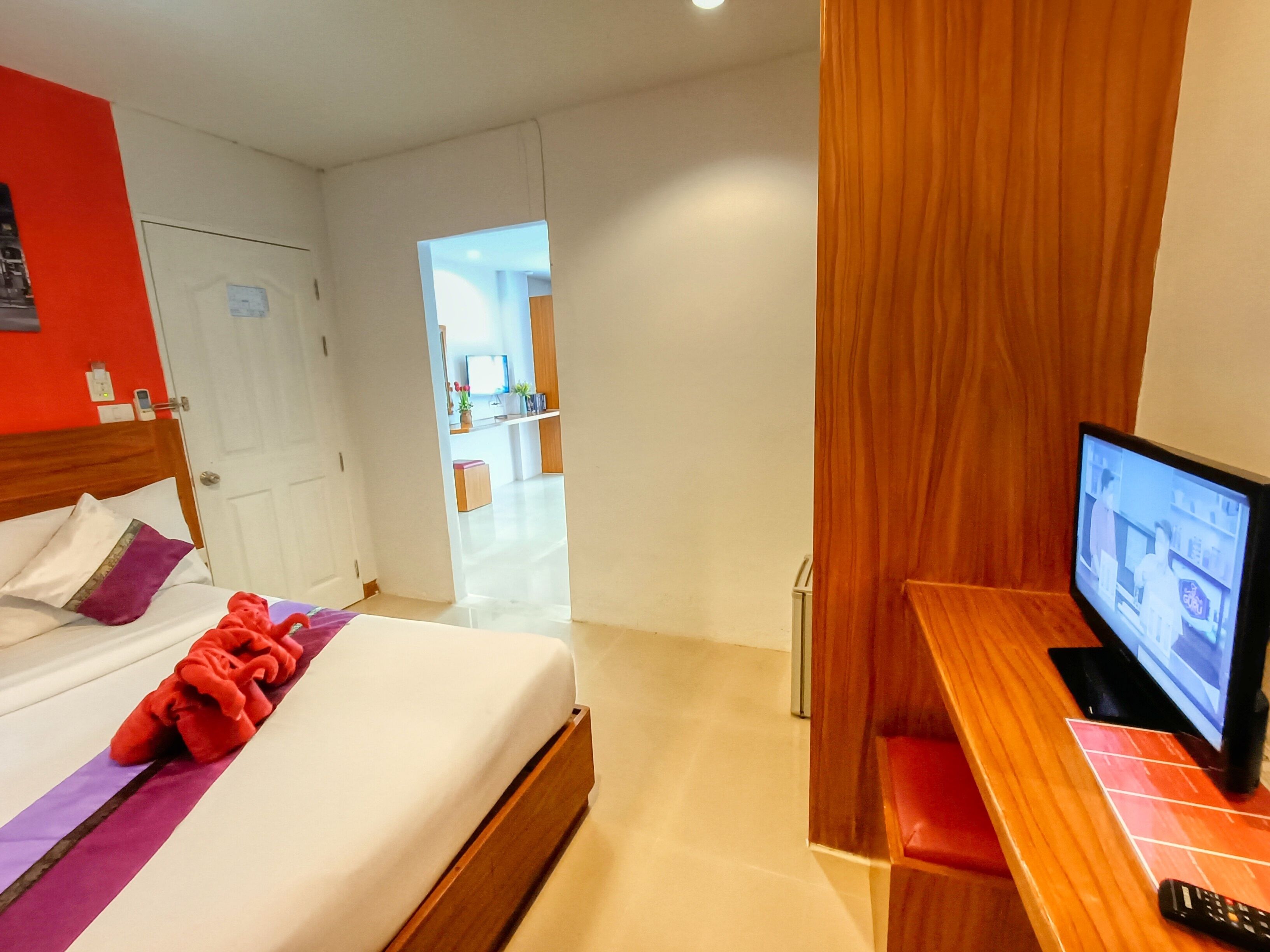 Ein Hotelzimmer mit einem Bett, einem Fernseher und einem Holztisch.