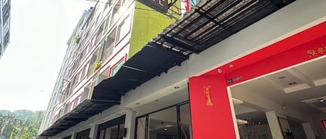 A multi-story building with a prominent sign for "PATRONG Resort".