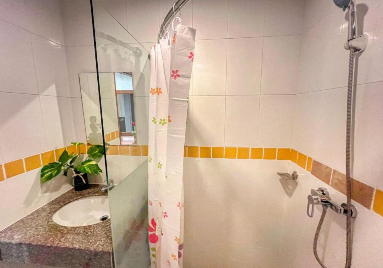A bathroom with a sink, a shower with a glass partition, and a mirror.
