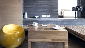 Habitación de hotel moderna con una mesa de madera, una silla amarilla, una cama y vista a la ciudad.