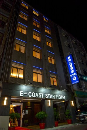 The exterior of the E-Coast Star Hotel with illuminated windows and a prominent hotel sign.