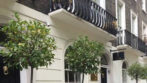 A traditional townhouse with a black wrought iron fence, white trim, and a sign indicating 'The Melville'. - The Melville Hotel by Rokxy - Kings Cross (London)