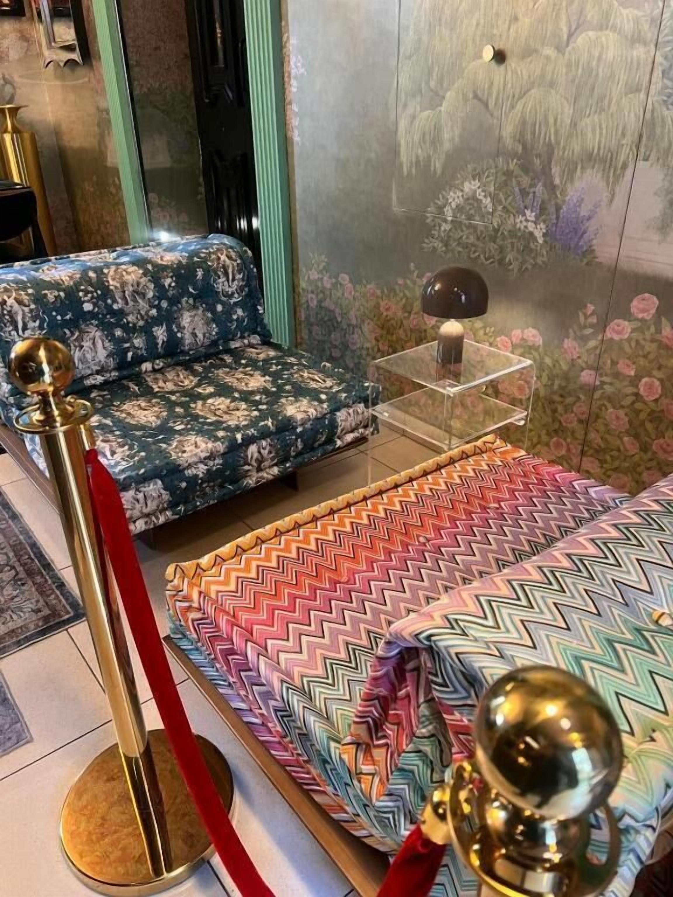 A room with a sofa set, a patterned rug, and a decorative lamp.