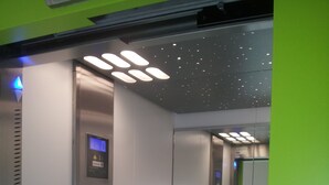 An elevator interior with a digital display, emergency instructions, and a handrail. - Fasthôtel Dunkerque (Grande-Synthe)