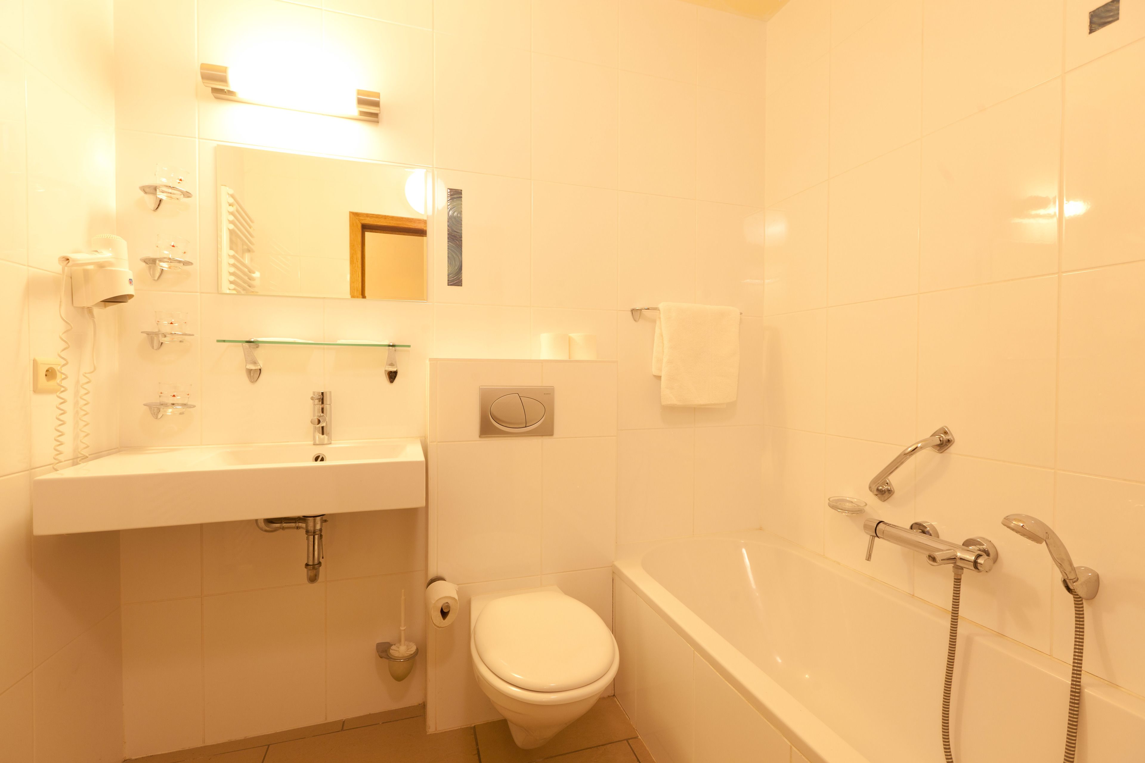 A bathroom with a white sink, toilet, and bathtub.