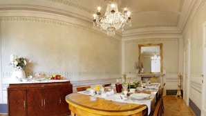 A formal dining room with a chandelier, a wooden dining table, and a mirror on the wall. - Residenza d'Epoca - B&B Santa Caterina (Pisa)