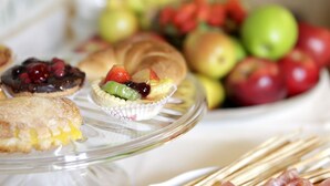 A glass serving tray with various pastries and a bowl of fruit. - Residenza d'Epoca - B&B Santa Caterina (Pisa)