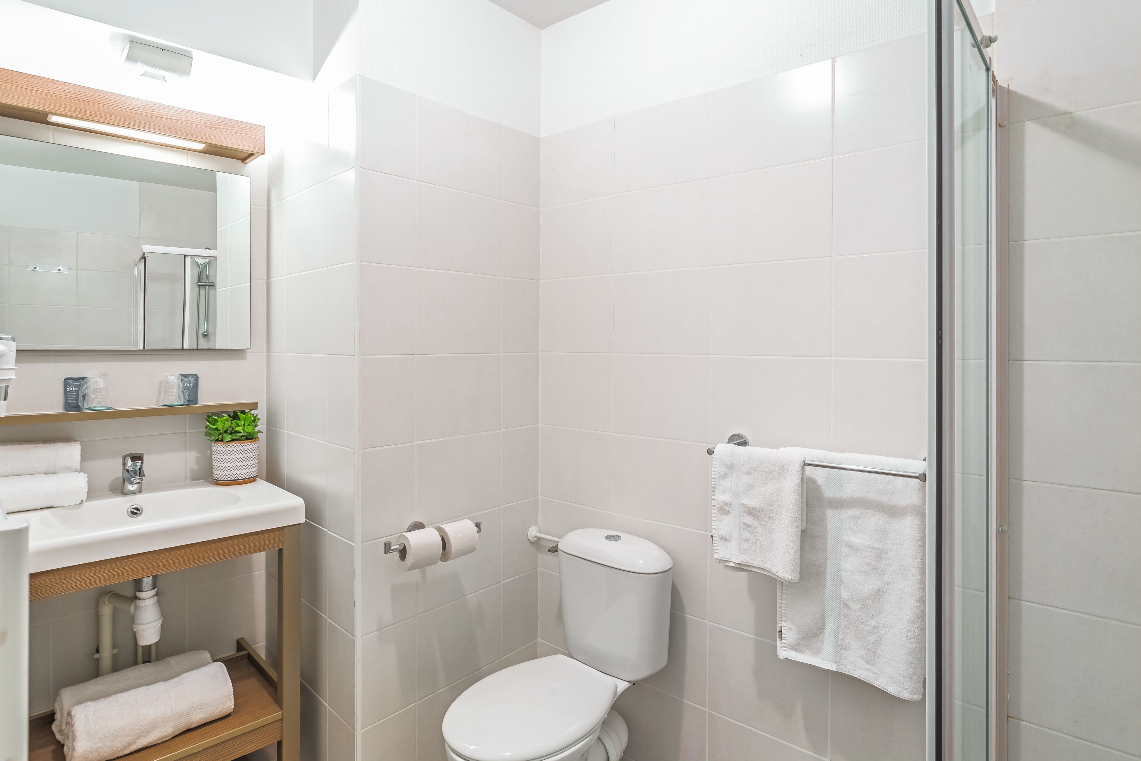 Een moderne badkamer met toilet, wastafel en douche.