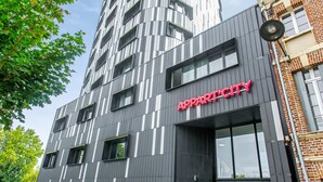 Een modern gebouw met een verticaal gestreept gevel en een bord waarop 