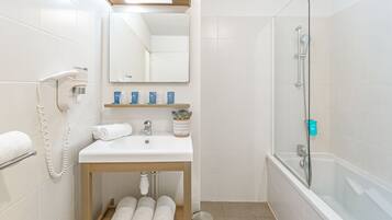 Une salle de bain moderne avec un lavabo blanc, un miroir et une douche.