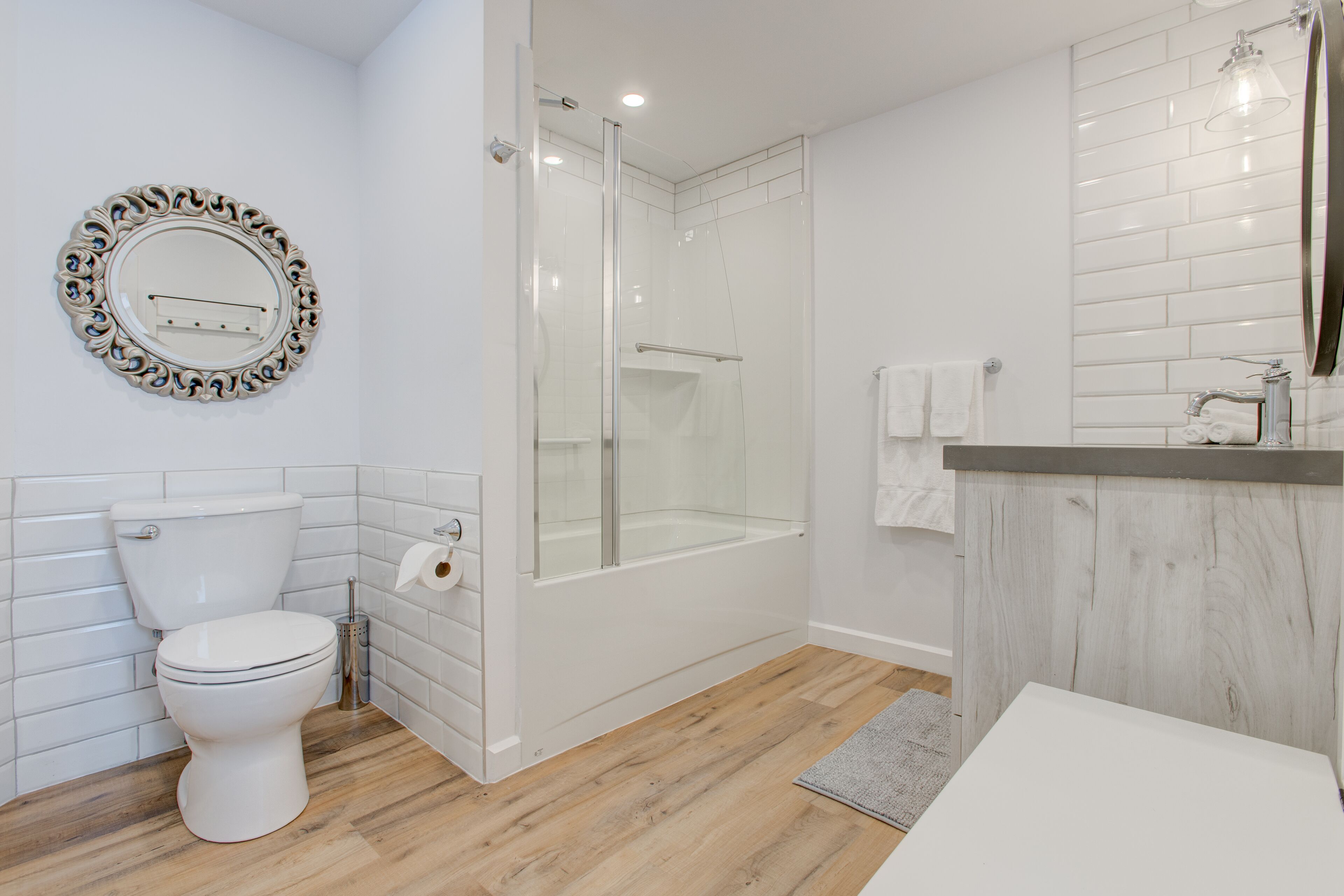 A modern bathroom with a toilet, shower, and sink.