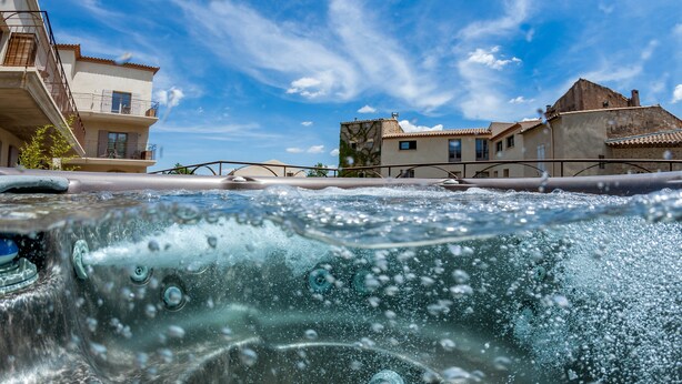 Un jacuzzi con vistas a edificios y un cielo despejado.