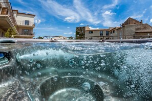Un jacuzzi con vistas a edificios y un cielo despejado.