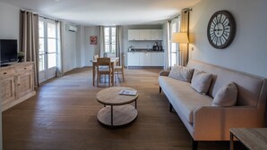 Una sala de estar moderna con un sofá, una mesa redonda de centro y un comedor con sillas.