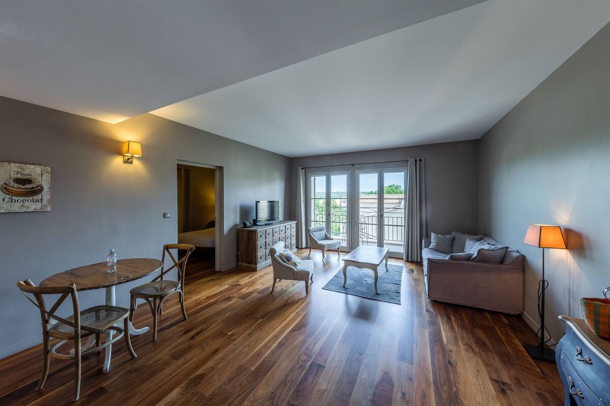 Un amplio espacio de sala con una mesa de comedor, sillas, un sofá y un mueble para la televisión.