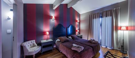 A bedroom with a bed, bedside tables, a chair, and a wardrobe.