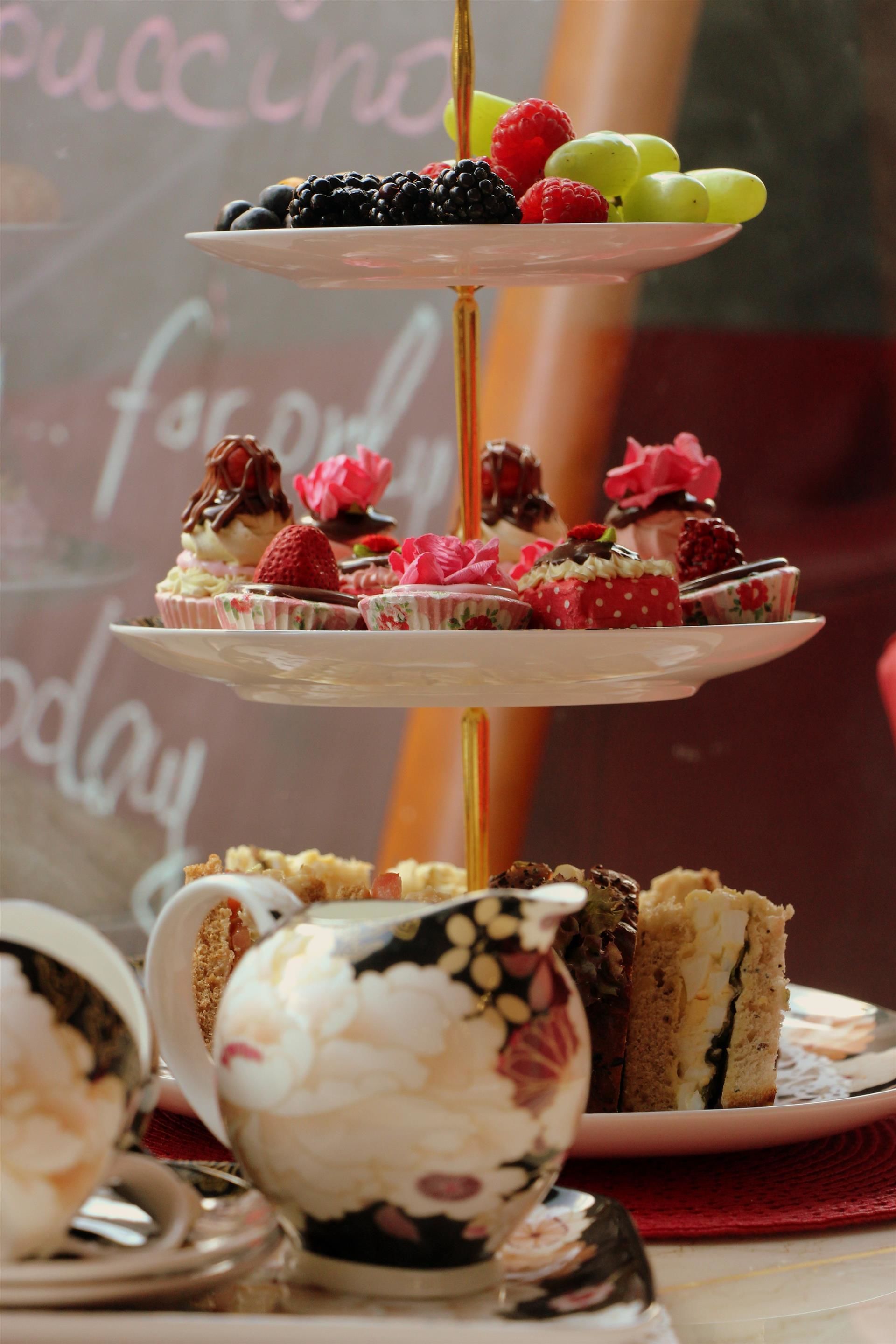 A tiered dessert stand with various pastries and fruits.