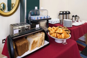 A breakfast buffet with bread, croissants, and coffee. - Best Western Greater London Hotel (Ilford)